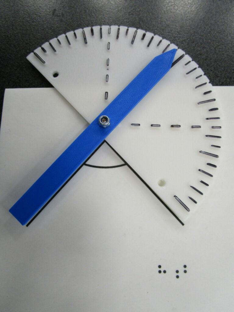 Protractor on a tactile drawing. The arm and base of the protractor forms the angle. The pointed end of the arm shows the angle measurement